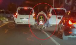 Motosiklet sürücüsü trafikte kaskı başına takması yerine arkasına bağladı