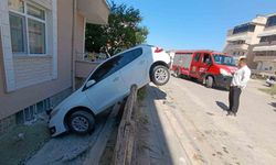Otomobil bahçe duvarına asılı kaldı