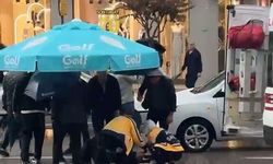 Yolun karşısına geçerken otomobil çarptı: Vatandaşlar yaralıya şemsiye tuttu