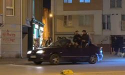 Seyir halindeki otomobillin bagajına ters oturan şahıs dikkat çekti
