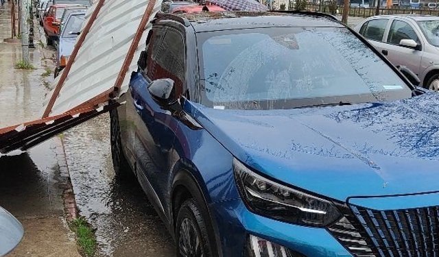 Fırtınanın etkisiyle yapıdan kopan parça araca zarar verdi